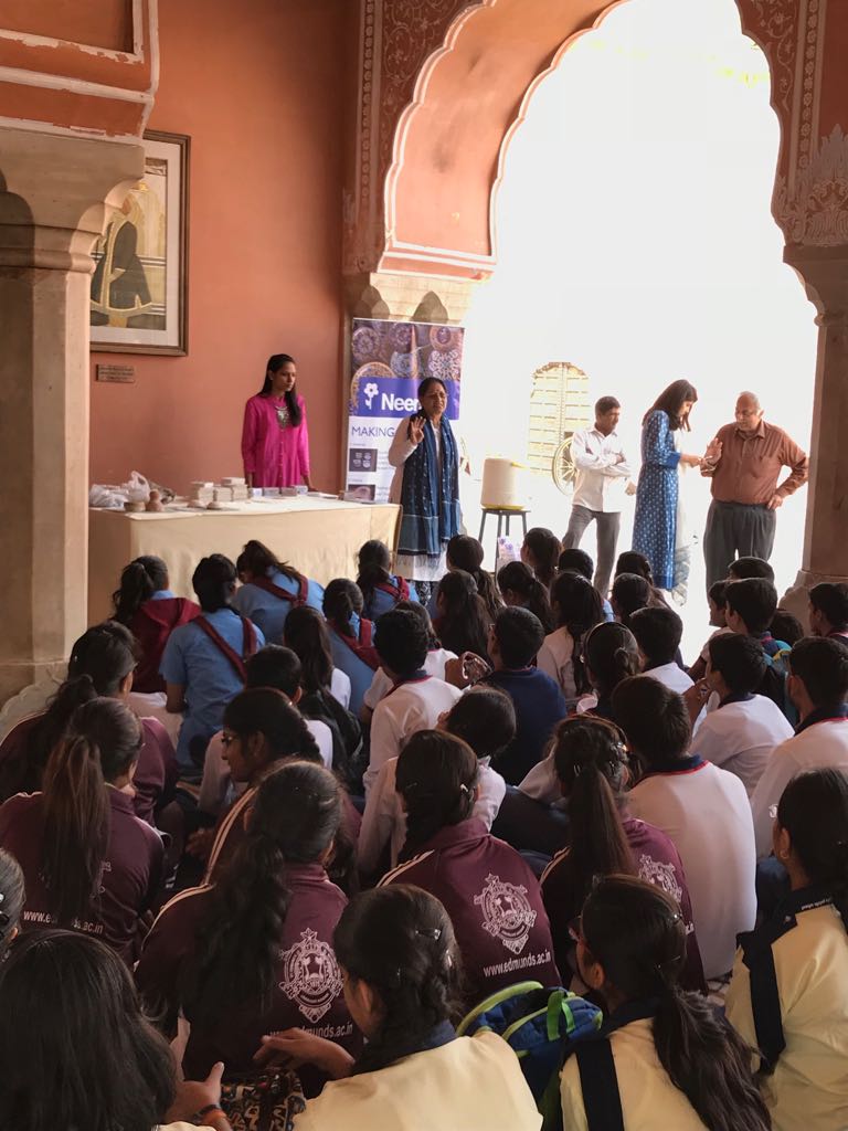 Ma'am showing the blue pottery ingredients to the childrens