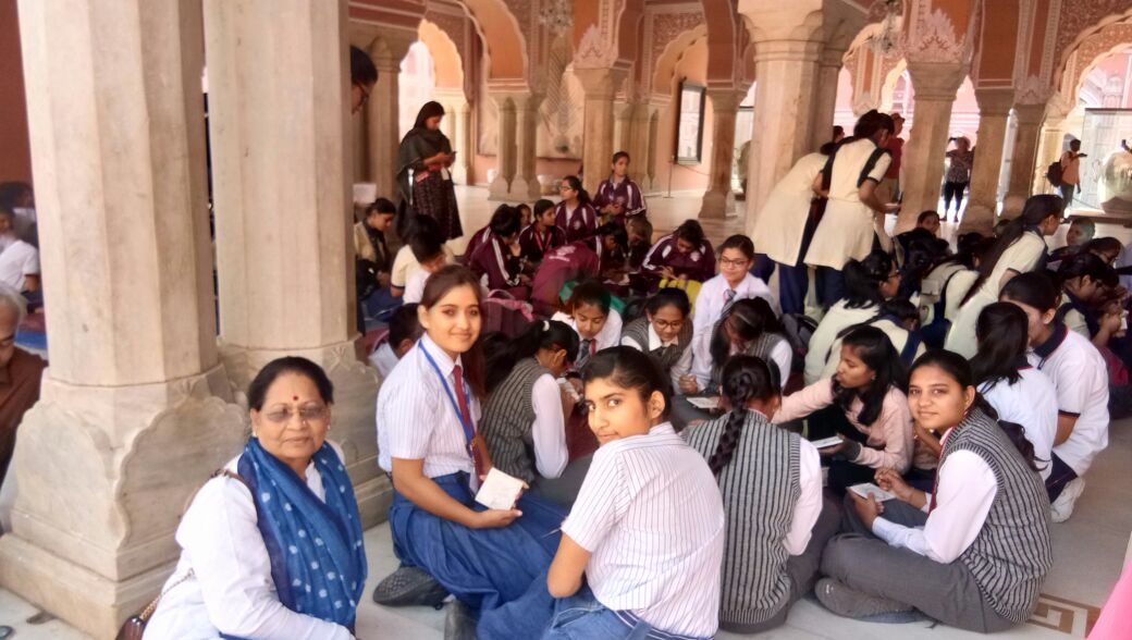 Ma'am sitting with children and guiding them