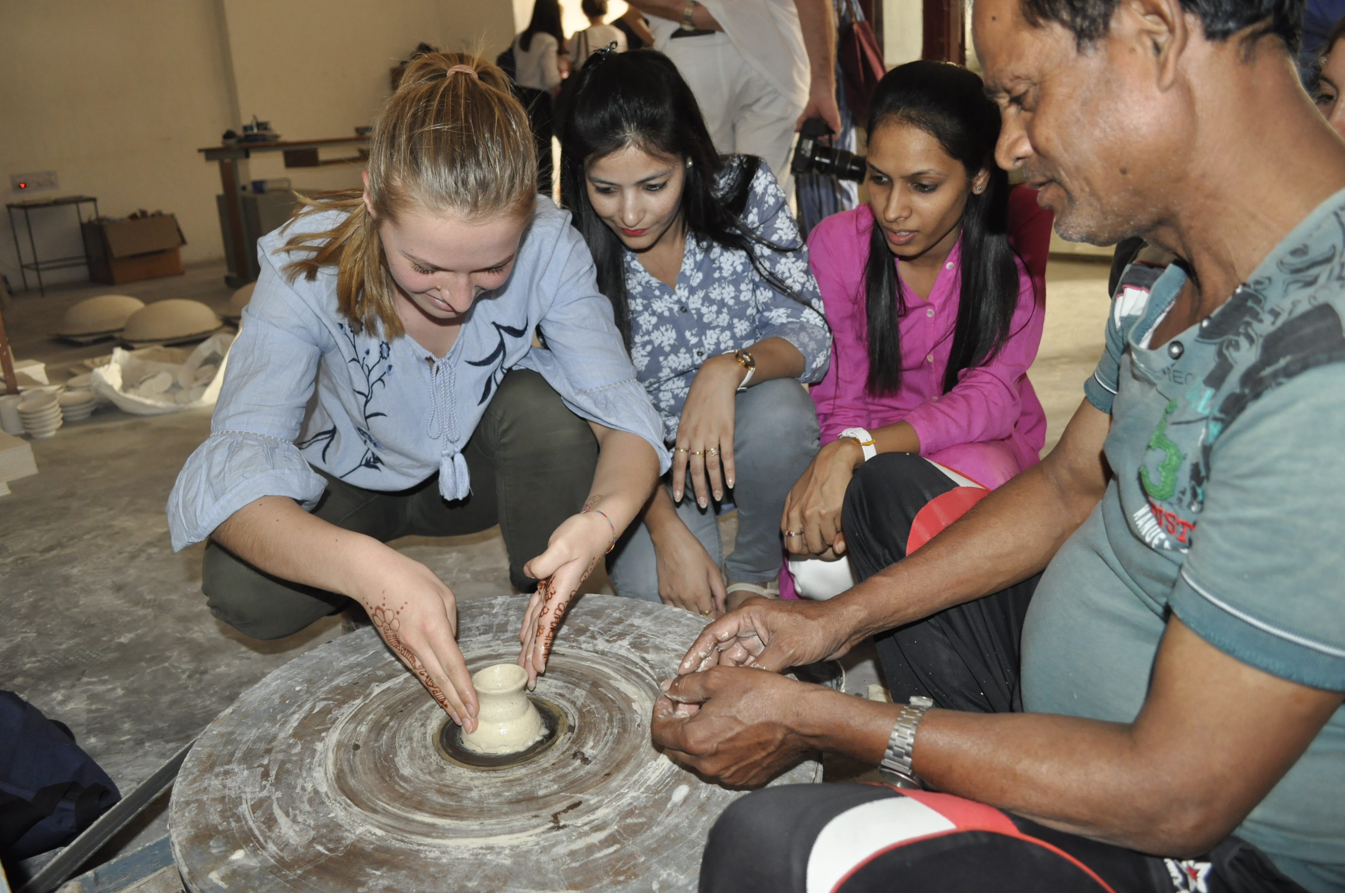 Students trying their hands on Blue Pottery wheel